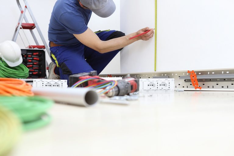 Un électricien installe les circuits électriques d'une maison